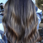 Long, wavy hair with brown and blonde highlights, shown from the back.